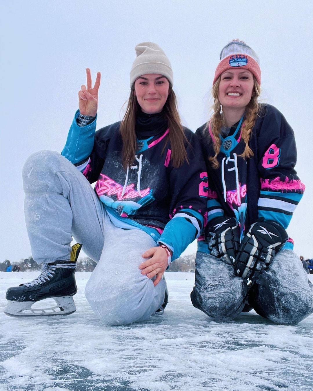 Two ladies playing pond hockey in their custom hockey jerseys