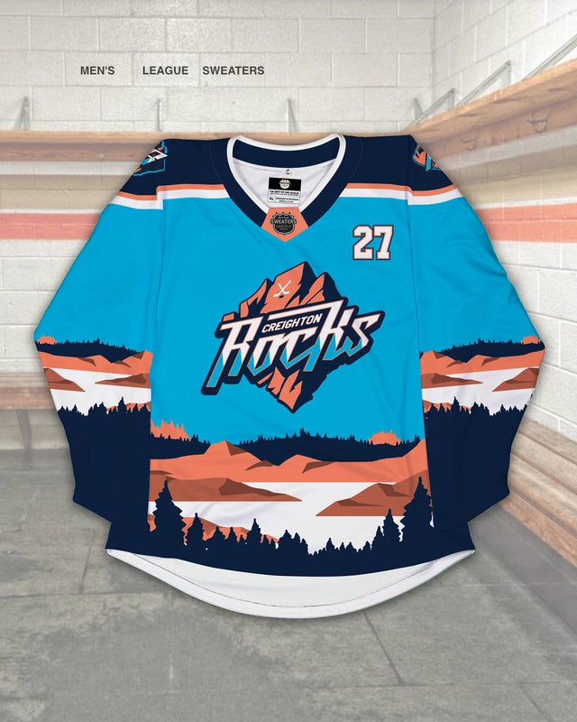 Custom blue hockey jersey design with tan mountain and shadowed tree landscape 
