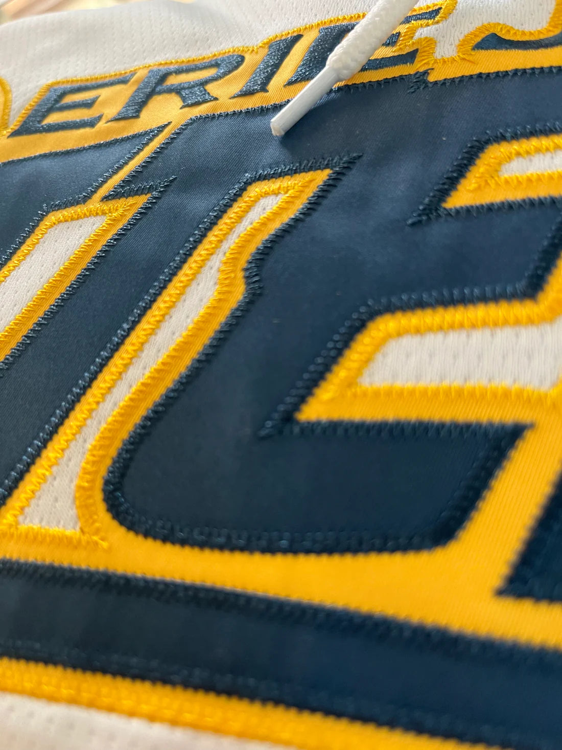 Close up of a custom hockey jersey in embroidered tackle twill